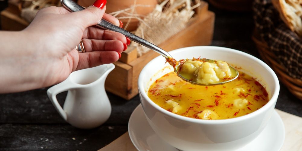 side view a girl eats dushbara soup a traditional azerbaijani dish
