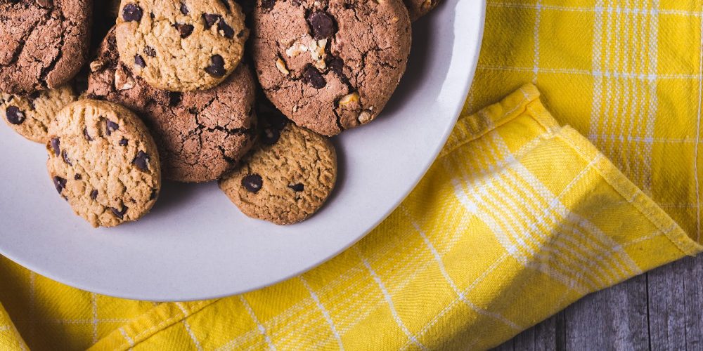 A closeup shot of a lot of chocolate chip cookies in a white plate